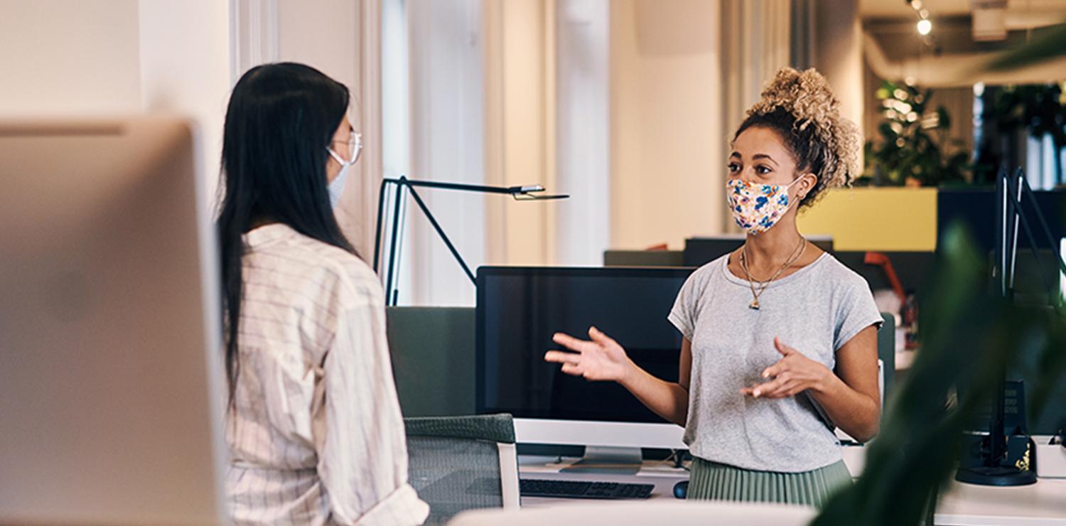 To personer med mundbind taler sammen