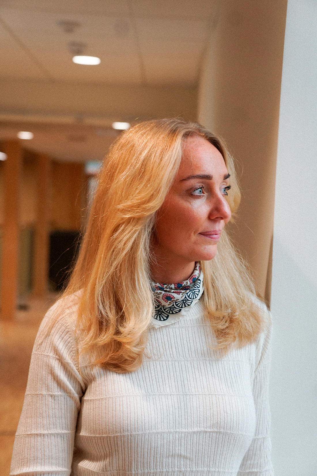 Louise kigger tænksomt ud af et vindue